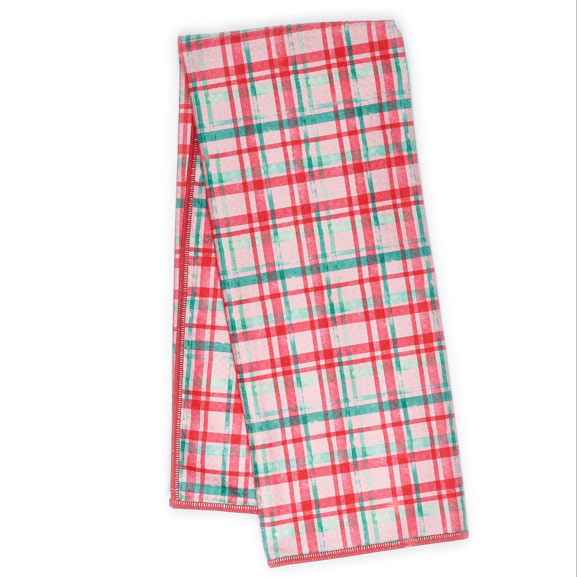 Folded tea towel with Christmas tree pattern on a pink background
