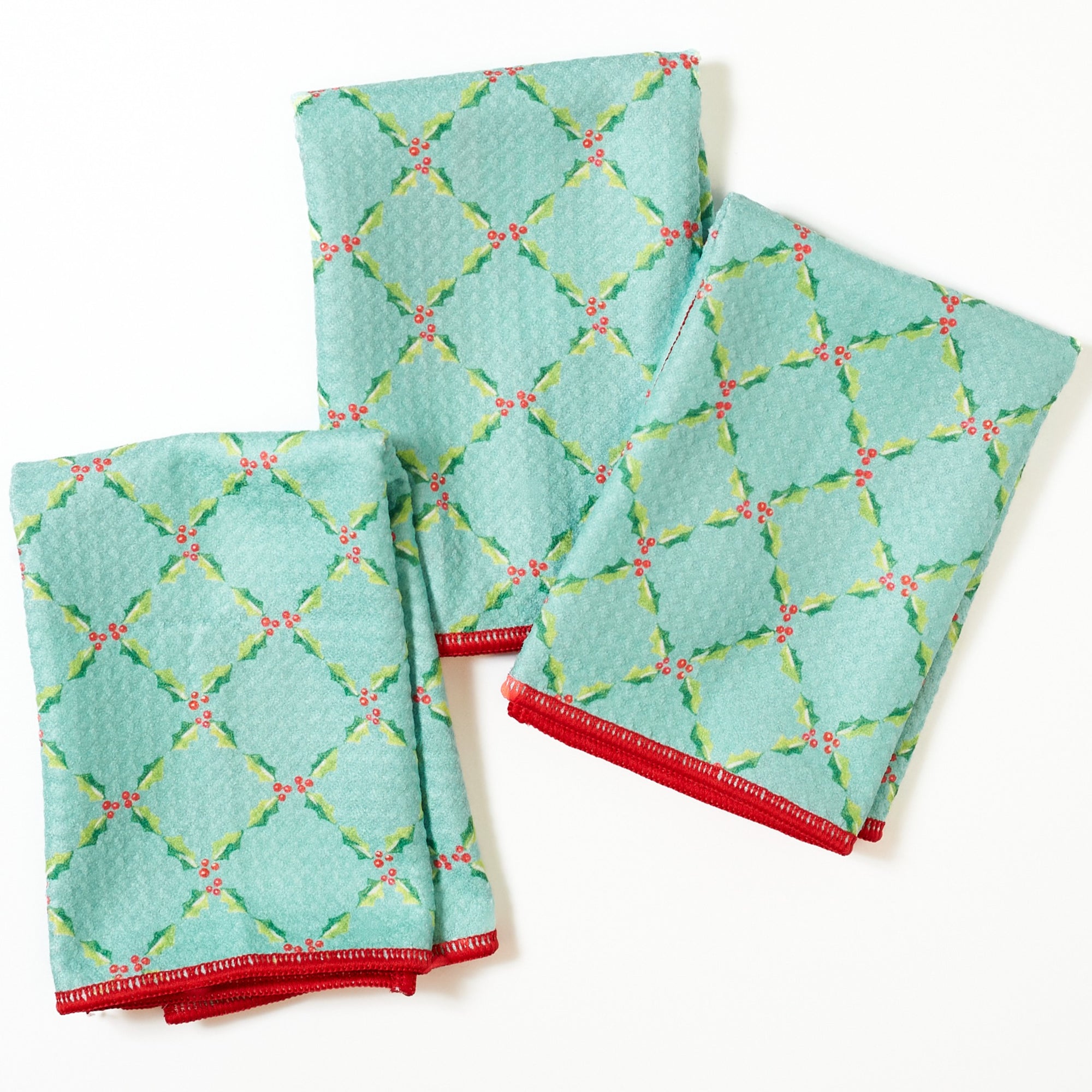 Set of three red napkins with Santa Claus pattern on a white background