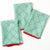Set of three red napkins with Santa Claus pattern on a white background
