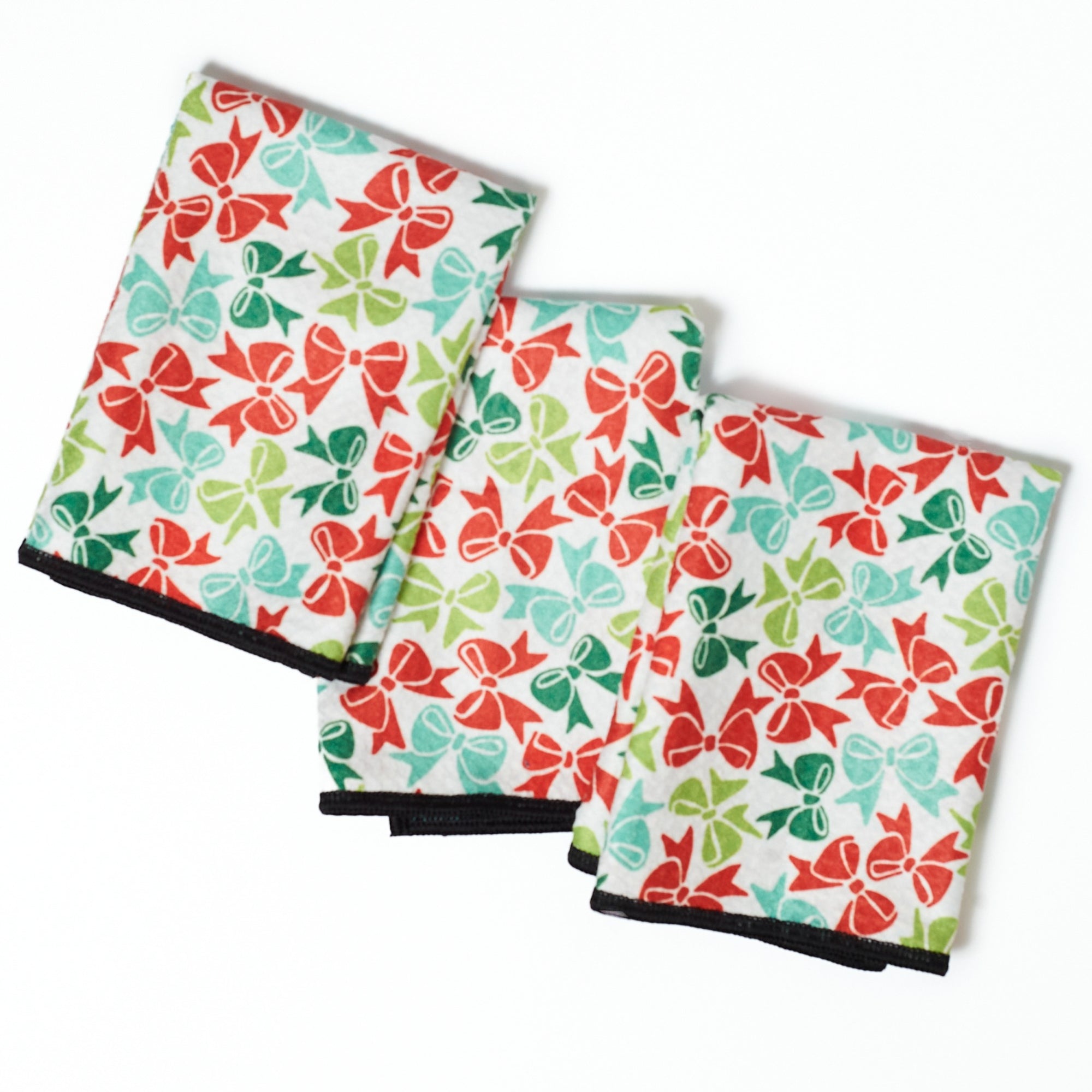 Set of three folded towels with black Scottie dog silhouette pattern on a turquoise background