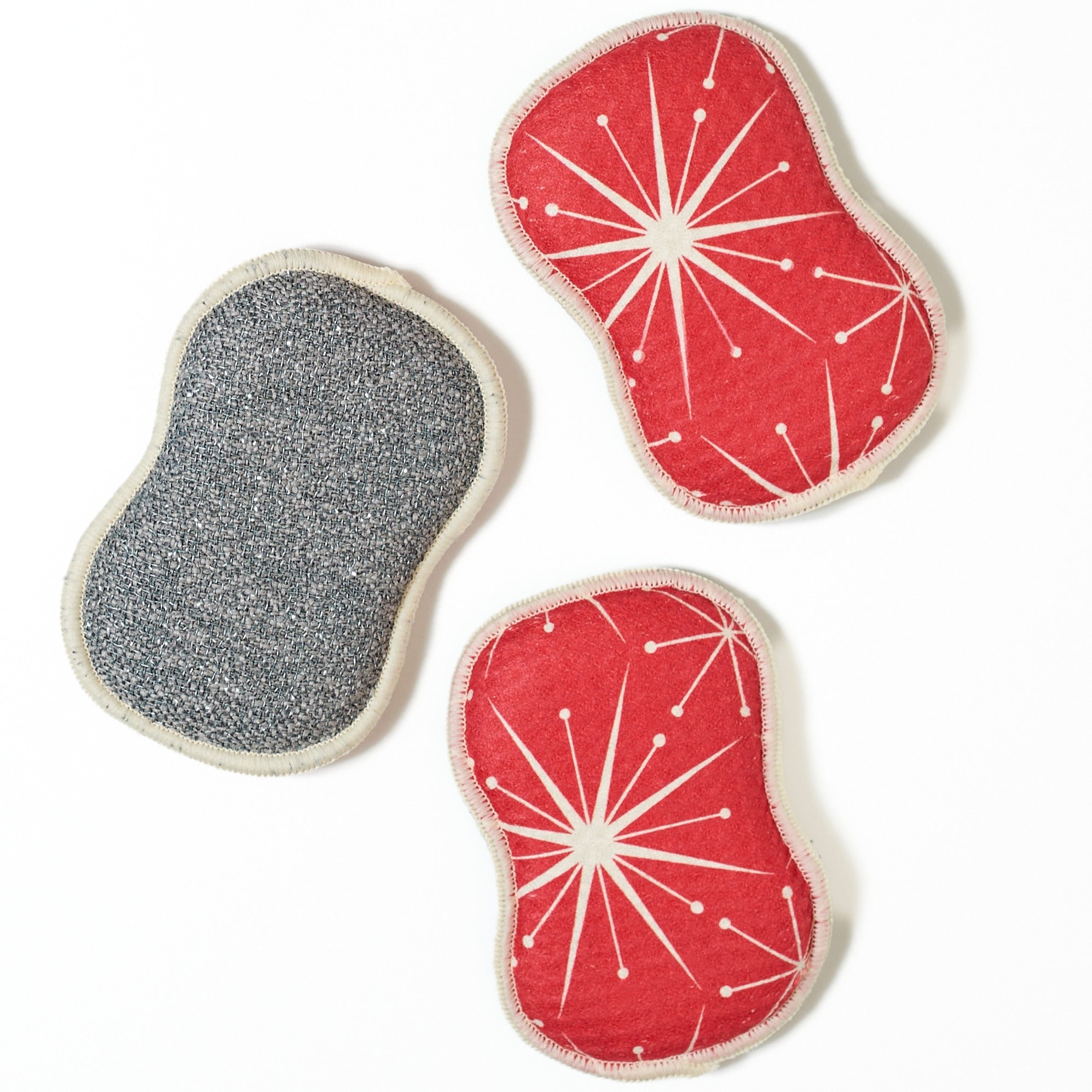 Three red washable sponges with white starburst patterns on a white background