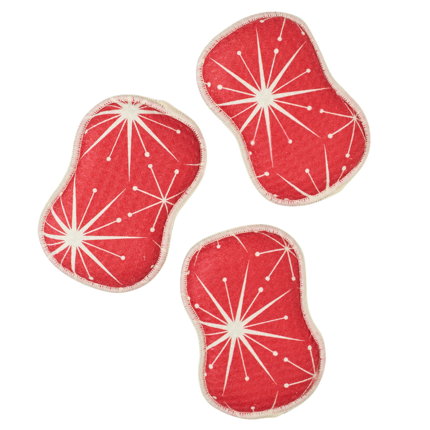 Three red washable sponges with white starburst patterns on a white background