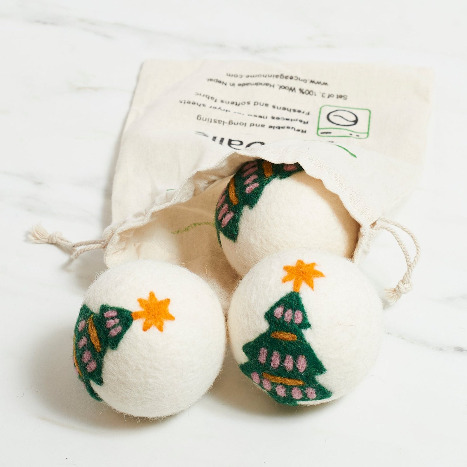 Three dryer balls with Christmas tree designs on a white background
