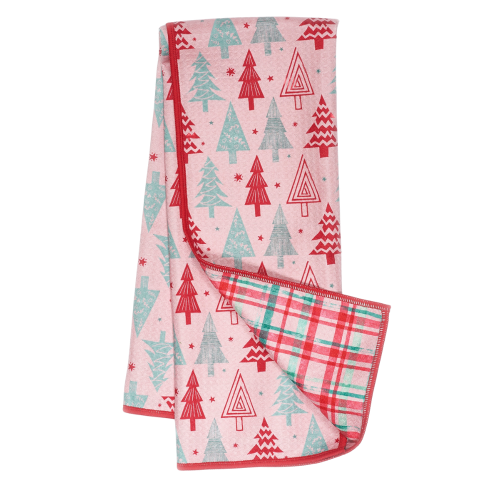 Folded tea towel with Christmas tree pattern on a pink background