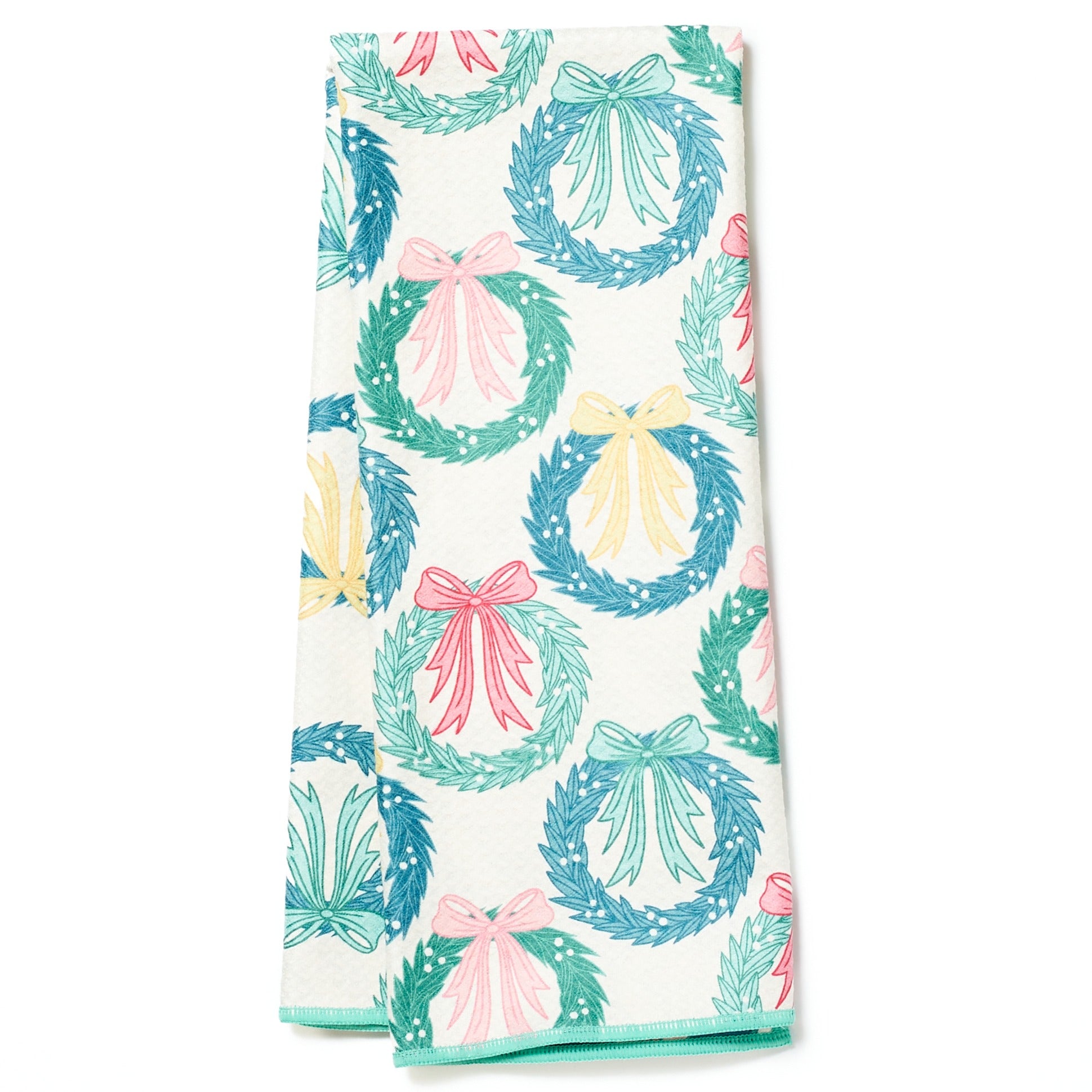 Folded tea towel from Rebecca Jane Woolbright with wreath and bow pattern on a white background
